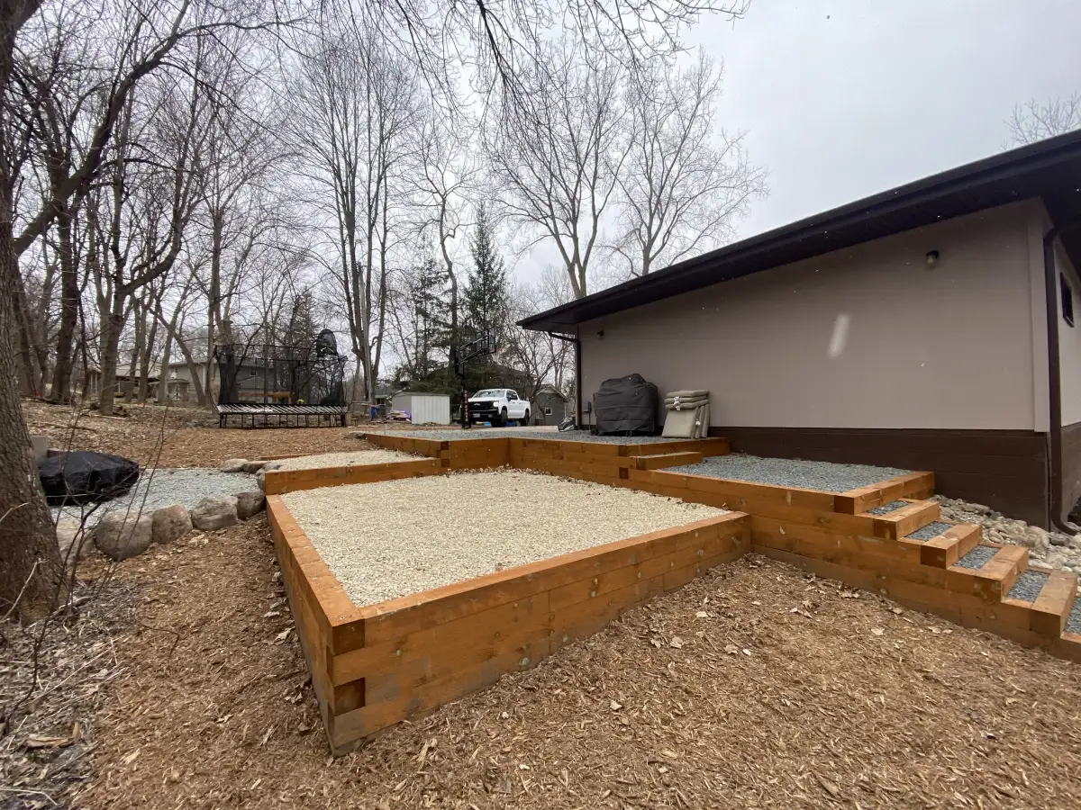 Hillside after retaining wall installation with tiered beds