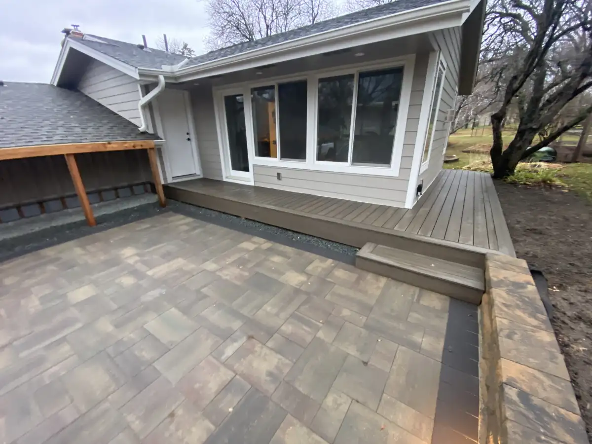 Elevated deck overlooking landscaped backyard with retaining wall