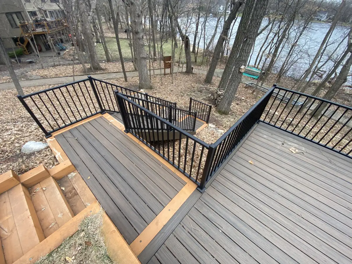 Multi-level deck with staircase connecting to paver patio below