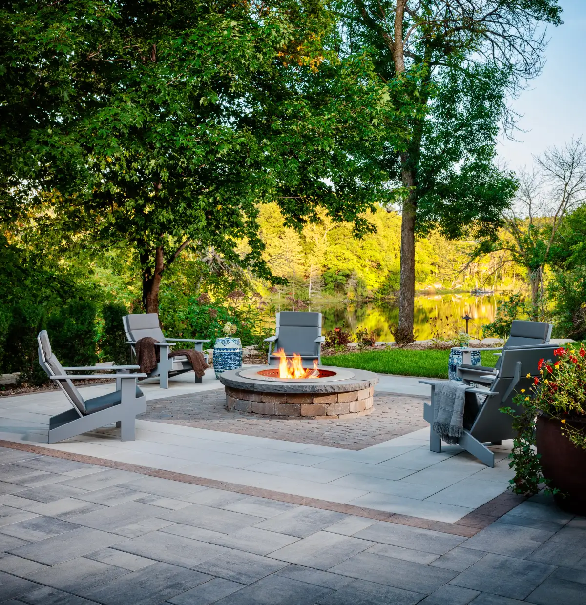 Gas fire pit with seating wall on paver patio at twilight