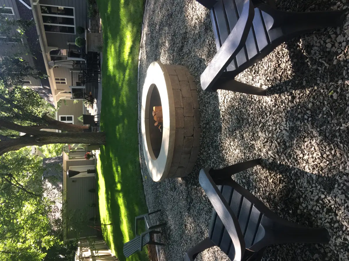 Outdoor fireplace with stone veneer and accent lighting