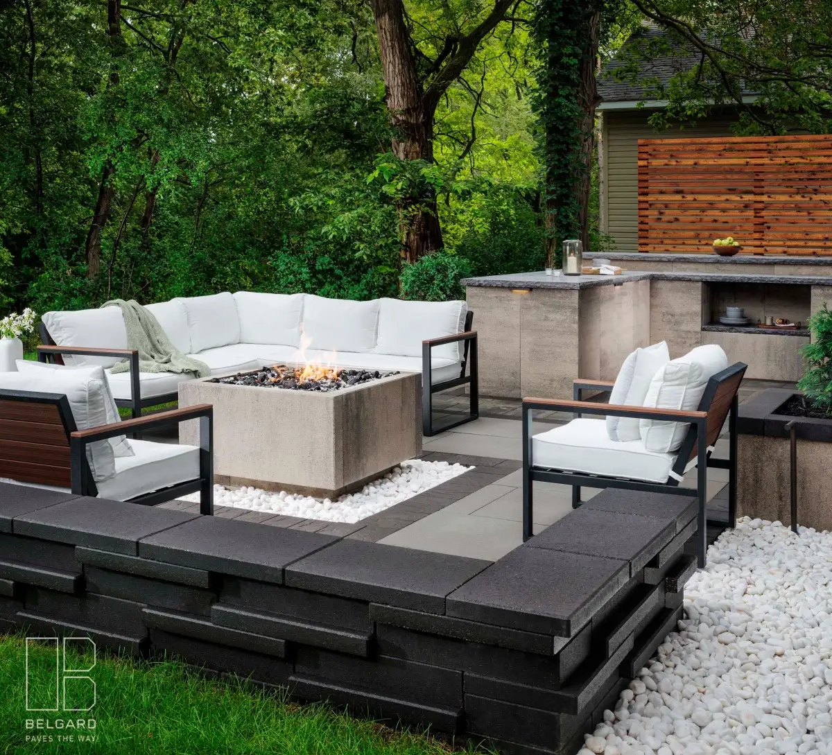 Estate tier patio with fire pit, outdoor kitchen, and cedar privacy screen — $50-75K project by Landscape Charlie
