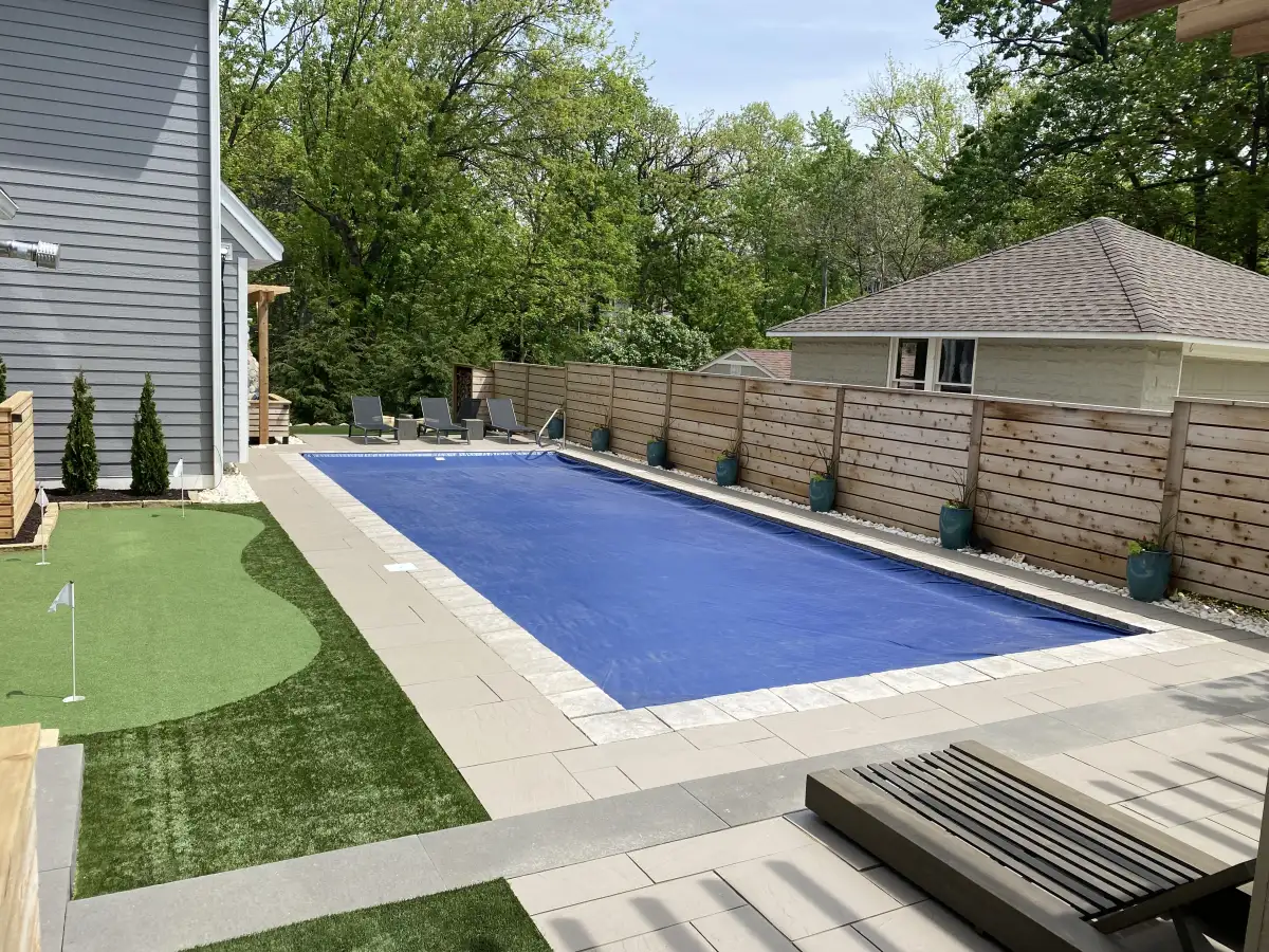 Legacy tier pool with putting green and cedar privacy fencing — $150K+ total property transformation