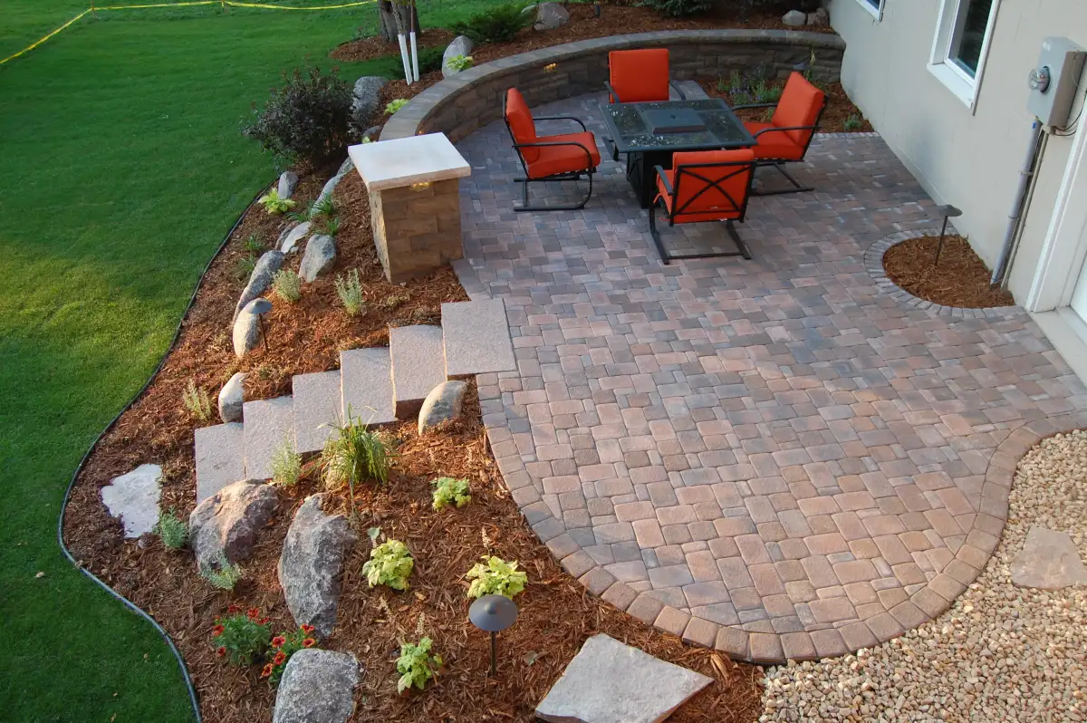 Expansive backyard patio with sitting wall and landscape border