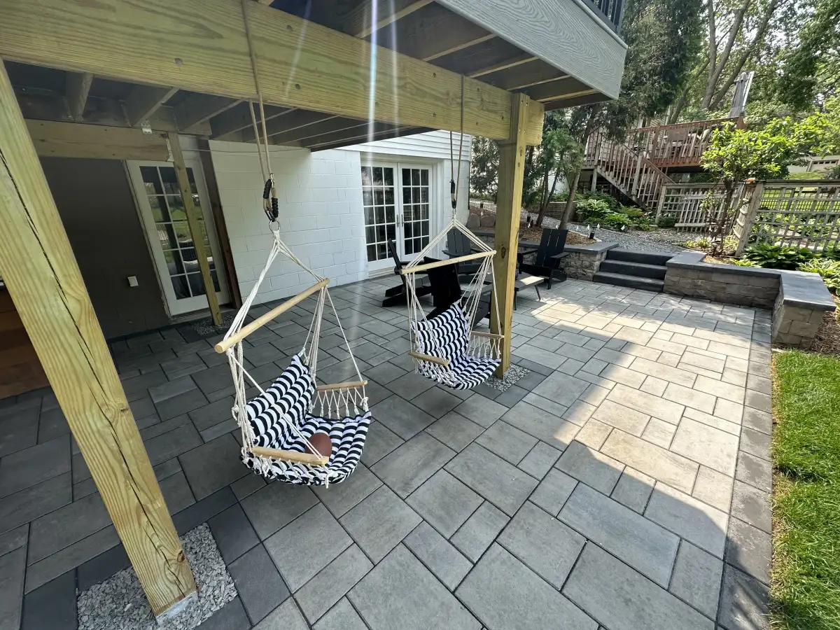Paver patio with covered seating, steps, walls, and connections to the yard