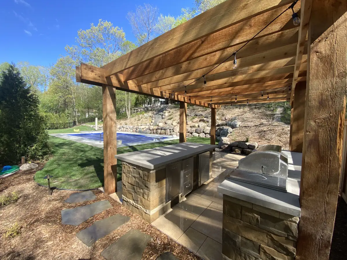 Large pergola with louvered roof panels and string lighting