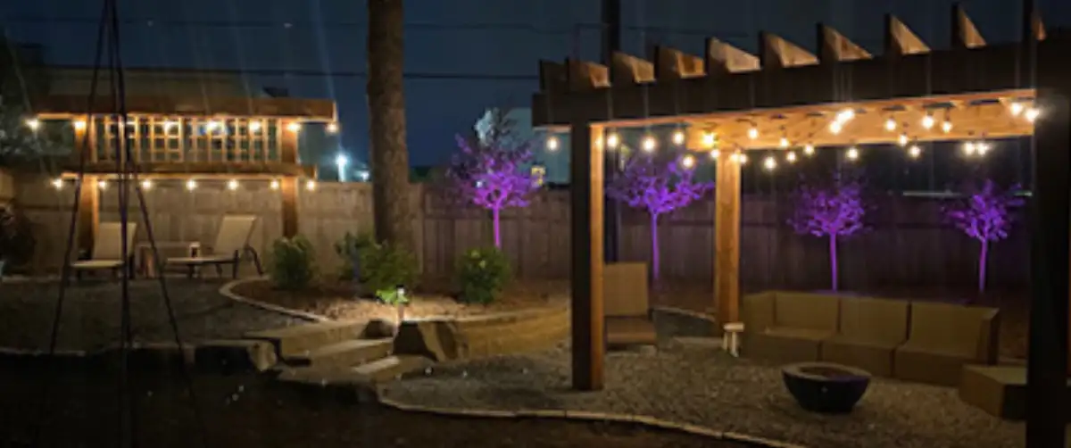 Cedar pergola with landscape lighting over patio in Plymouth