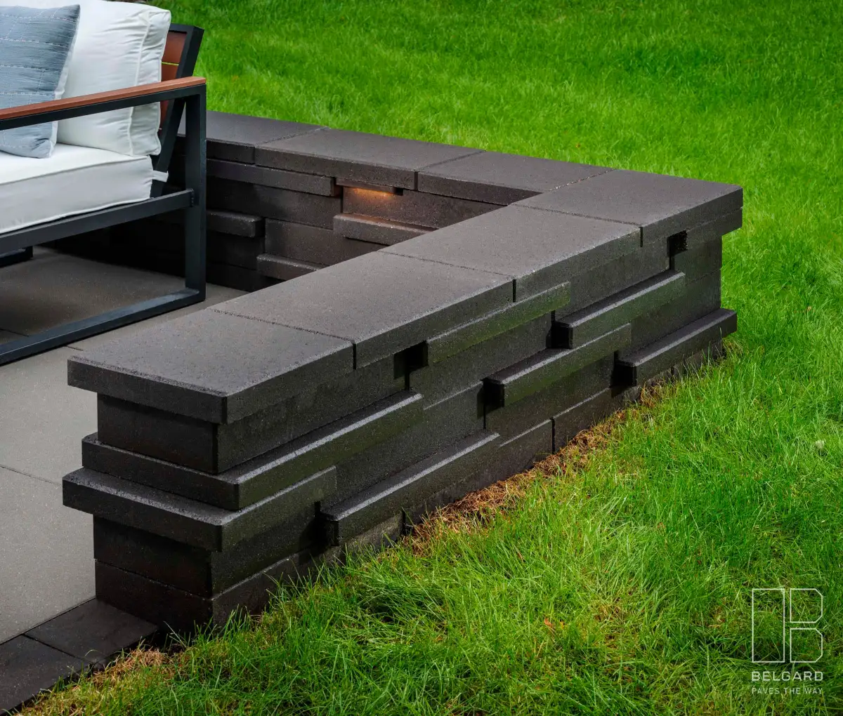 Natural stone retaining wall with boulder accents along hillside